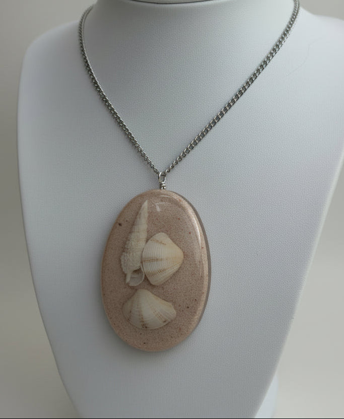 Necklace with a pendant featuring shells and beads on a mannequin.